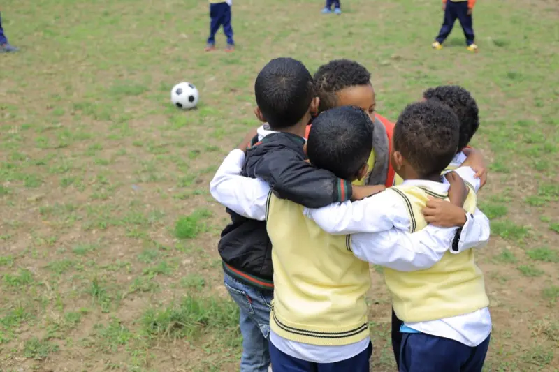 Boys huddle on the football field.