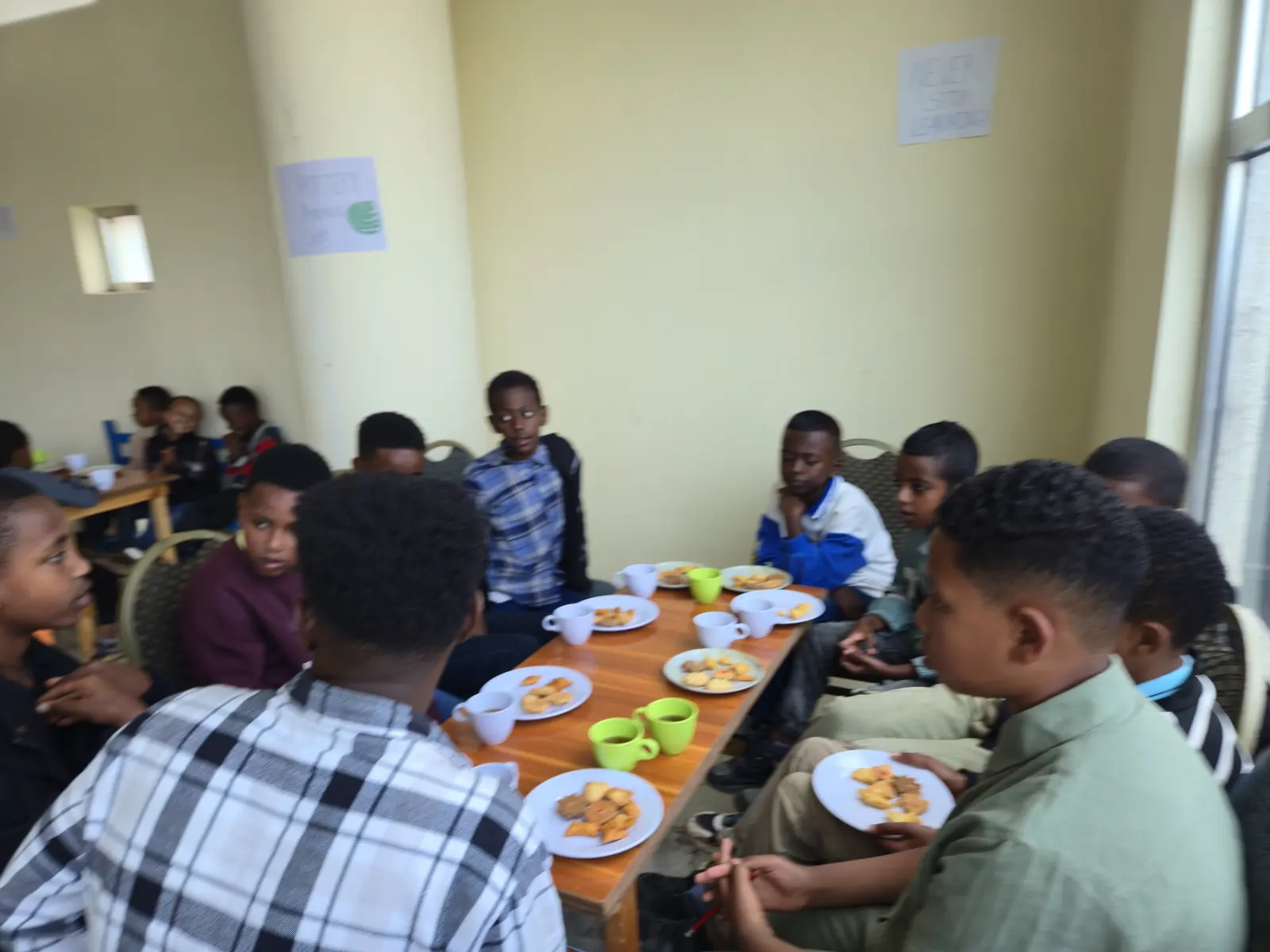 Older children talk around a table during snack time.