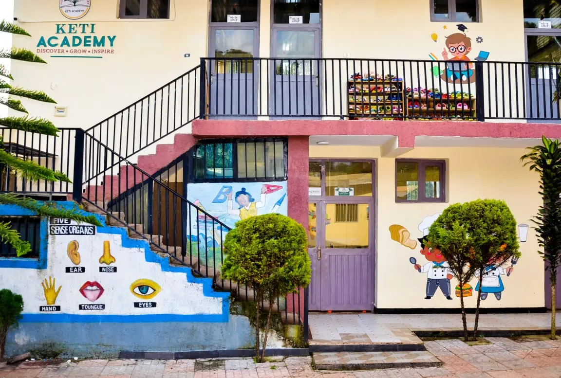 The Keti Academy KG building with its painted stairs, sense-organ mural and balcony.