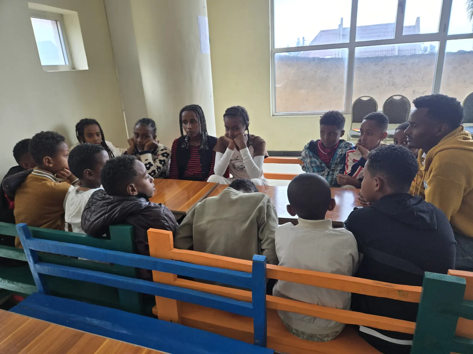 A group of students talk together at library tables.