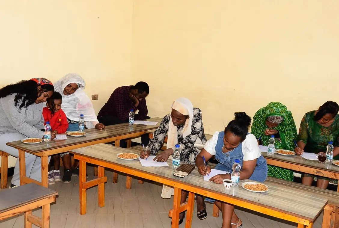 Parents and grandparents complete forms at classroom benches.