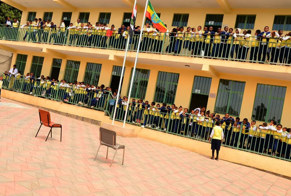 Students line all three balconies of the Primary and Junior High building as the flag is raised.